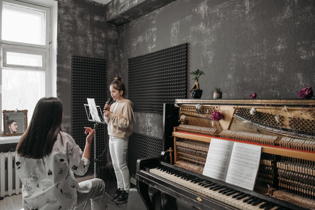 Crafting Captivating Headlines: Your awesome post title goes here A young girl takes a vocal lesson in a soundproof music studio with her teacher.